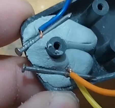 Agora prenda os parafusos com a massa adesiva na parte superior da raquete, desse jeito. (não deixe os parafusos ficarem longe de mais nem encostados)