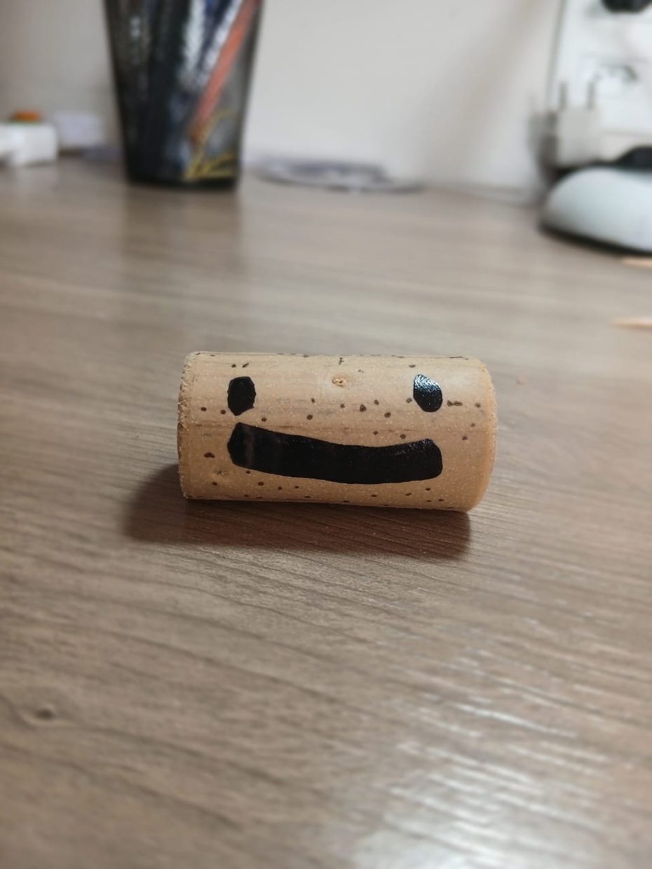 pegue a outra rolha e faça um rosto horizontalmente com a caneta permanente