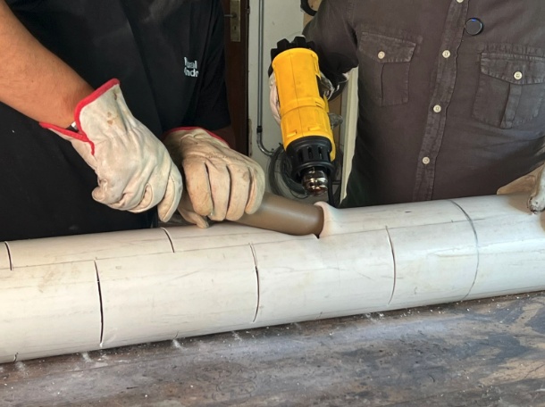 Encaixe o cano menor (de 5 cm cortado a 45°) na marca e pressione para fora, formando uma pequena “boca” inclinada.