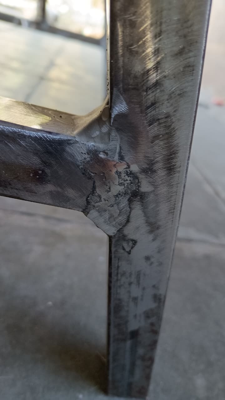 Faça uma pré-montagem da estrutura do "A" em uma superfície plana. Se não tiver outra vai no chão. Medir sempre umas 2 vezes ou mais antes de cortar ou soldar... Faça a união das peças de forma que fique uma solda bem reforçada. Para melhor acabamento use a esmerilhadeira para nivelar a solda.
Dicas: 01 - Fiz com os perfis de aço em espessura menor porque eram os que eu já tinha em casa, mas não recomendo principalmente para quem for soldador iniciante (igual a mim) devido à dificuldade bem maior de soldar perfis de aço mais finos... Furam com facilidade, por isso a dica de usar perfis na chapa 14.
Dicas: 02 - Com a solda com resistência adequada, não se preocupe com o acabamento e alguns furos, desde que esteja bem soldada é possivel tapar os mesmos com "durepox", e lixando e pintando por cima irá esconder perfeitamente os detalhes de acabamento.