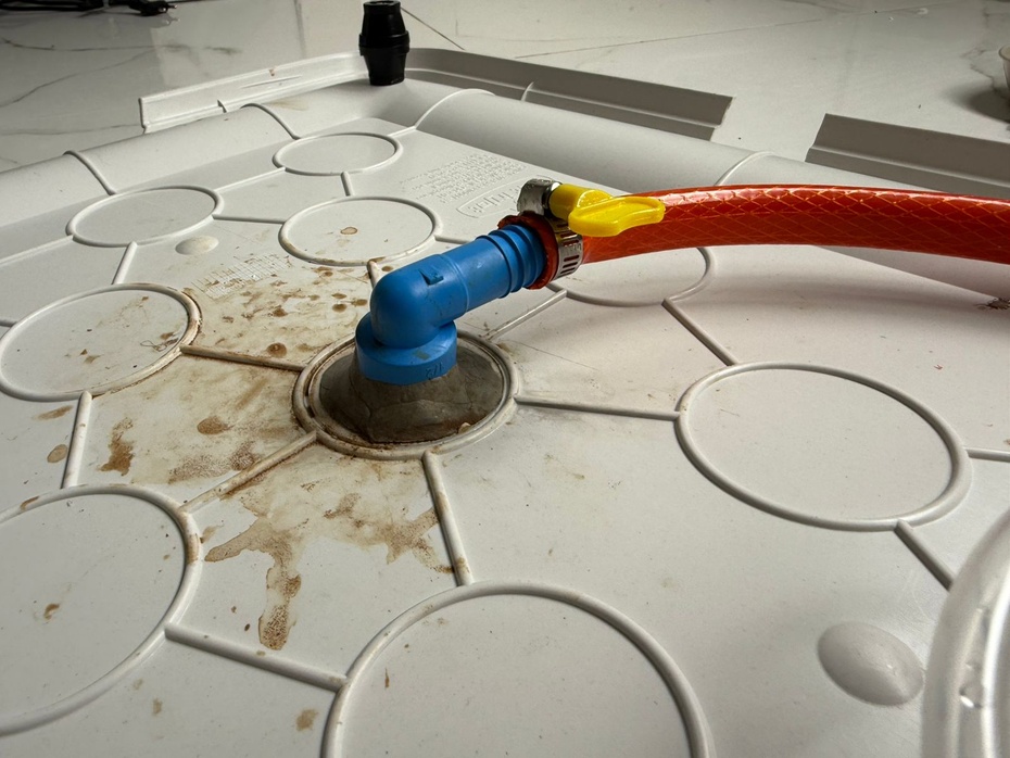 Antes de posicionar o joelho no furo maior, recomendo que concecte logo a mangueira com a abraçadeira para nao correr o risco de calcular mal a posição do joelho. Após isso, posicione o joelho no furo maior e central e o prenda com durepoxi, nesta etapa pode-se utilizar também o silicone para colar e posicionar o joelho no furo central. Espere secar BEM antes de jogar qualquer tipo de líquido. Caso deseje que seu sanitário seja conectado ao ralo, nosso passo a passo termina aqui. É so colocar a mangueira utilizada no ralo mais próximo e correr para o abraço! Note que neste caso, é necessário que tenha um ralo próximo ao local do sanitário, e essa formulação não permite ficar trocando o tapetinho de lugar. Caso deseje uma opção sem ralo é so seguir para a próxima etapa!