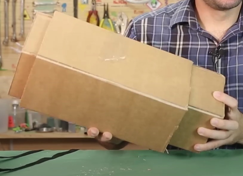 Com o estilete e régua faça um corte, sem atravessar o papelão, nas 3 linhas que separam os 4 retângulos, de modo que após cortados eles não se separem e sejam fáceis de dobrar. Este tubo receberá a lupa e nos ajudará a ajustar o foco do canhão de luz.