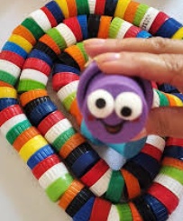 Na primeira tampinha (a "cabeça"), desenhe olhos com a canetinha. Se quiser, cole uma língua feita de papel vermelho.