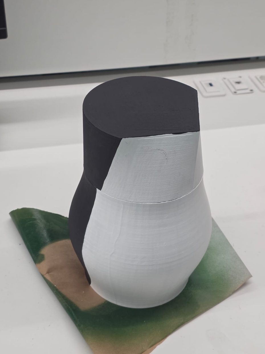 Pintura

Antes de pintar, veja o rótulo das embalagens das tintas spray e acrílica, conferindo o tempo de cura (secagem) e respeitando-o após passar cada camada de tinta para não comprometer a peça e o resultado da pintura. Para realizar a pintura, compreende-se o uso de um ambiente adequado, uma vez que existe a possibilidade de sujar o ambiente com o uso de tinta spray, além de máscaras e luvas para evitar futuros problemas de saúde. 

Nesse sentido, primeiro, deve-se lixar a cabeça e o corpo de PLA do pinguim. Em seguida, deve-se utilizar a tinta spray primer cinza para promover ainda mais absorção de tinta, posto que a superfície do PLA não é adequada para aplicação de tintas imediatamente, compreendendo duas camadas de primer. Em terceiro lugar, deve-se usar a tinta spray branca em todo o pinguim. Finalmente, use a tinta acrílica preta com os pincéis buscando aproximar-se da imagem dos personagens "Os Pinguins de Madagascar", isto é, no topo, atrás e em parte das laterais da cabeça, e atrás e nas laterais do corpo do pinguim.