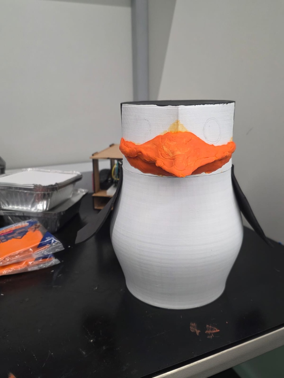Características únicas

Para inserir as nadadeiras do pinguim, deve-se recortar o EVA preto em forma de octógonos irregulares. Depois, basta colar uma das pontas de cada octógonos em cada lateral do corpo do pinguim. Por outro lado, para criar o bico do pinguim, foi necessário manusear uma massa biscuit laranja. Para efetuar essa tarefa, é necessário, primeiro, "sovar" a massa, ou seja, amassá-la para torná-la macia. Em segundo lugar, insira a massa na cabeça do pinguim, alisando-a e buscando construir uma base antes de construir o bico de fato. Em seguida, com uma base previamente feita, procure concentrar-se nos detalhes característicos de um bico, como a ponta e seu comprimento ao longo da cabeça.