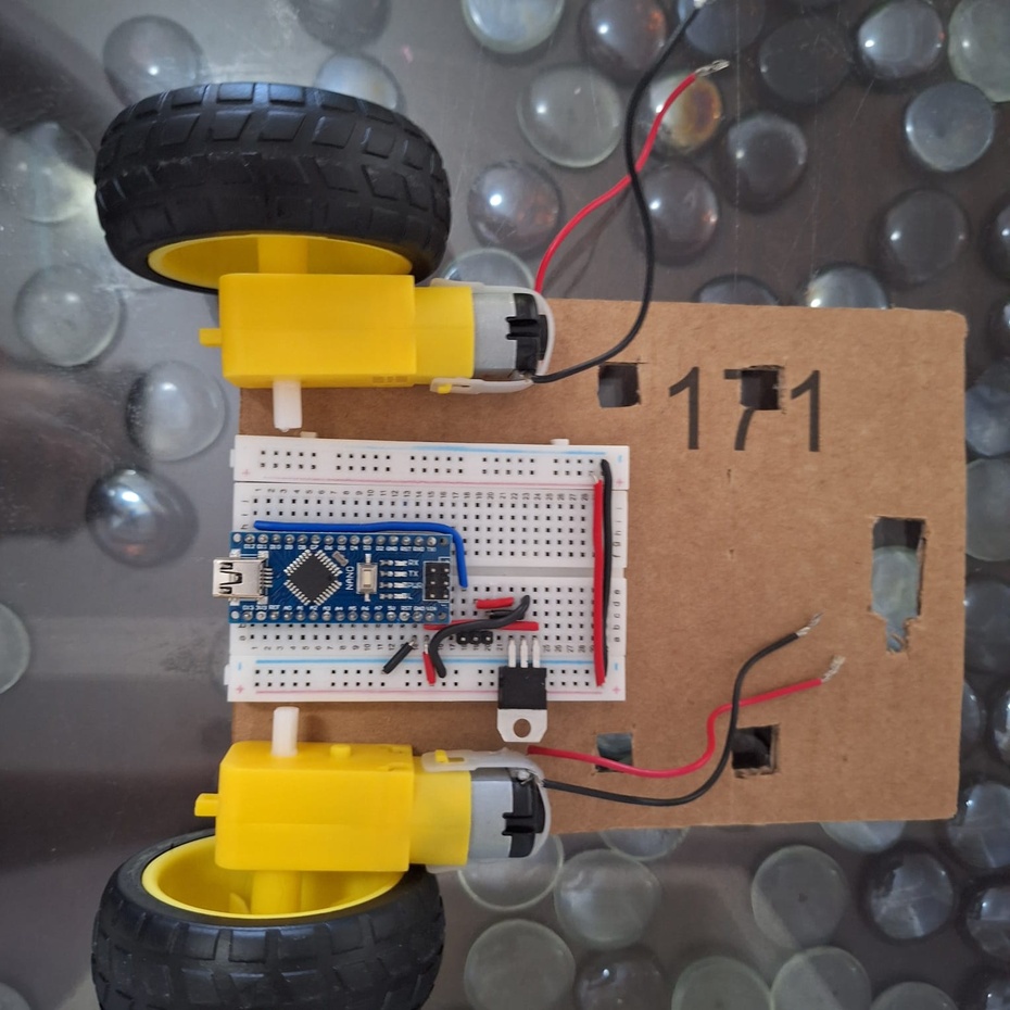 Retire o papel protetor abaixo da protoboard, expondo seu lado adesivo. Cole-a na parte de trás do Rolinho conforme a orientação da imagem.