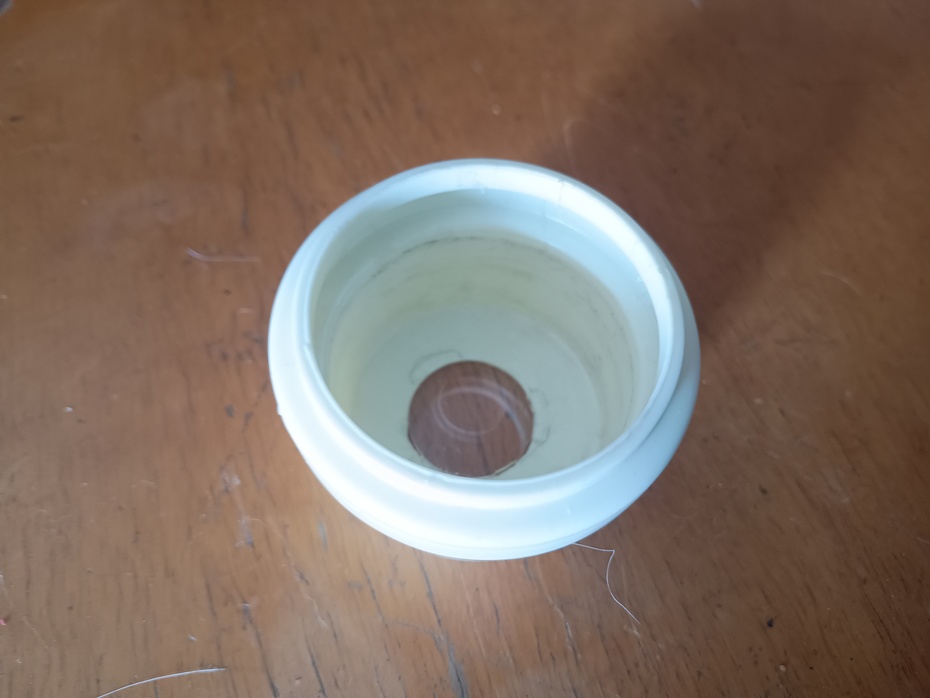 Colocar a lente menor no buraco na parte de dentro no cap com cola quente. Caso o furo dique maior que a lente, podemos corrigir isso com um pouco de cola quente. Cuidado, não podemos sujar a lente de cola quente, apenas aplica-la nas bordas da lente!