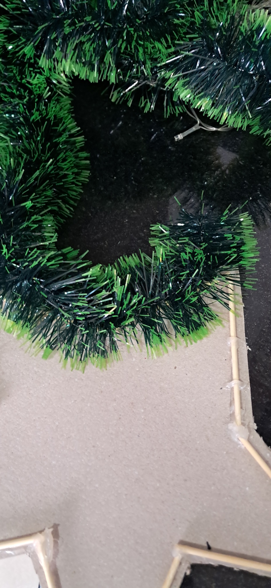 1- Pegue a estrela e o festão.
2- Pegue o arame.
3- amare o festão na estrela fazendo um furo pequeno com o estilete e passando o arame pelo furo e  por fora da estrela (encima do palito).