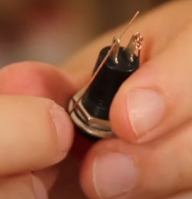 Passe uma das pontas deste fio no outro terminal do botão. Enrole para evitar que desconecte e passe fita isolante para evitar o contato com o outro terminal.