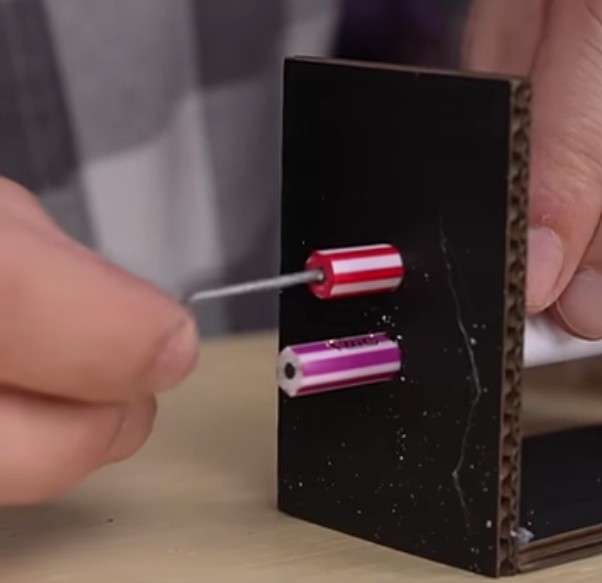 Coloque uma gota de cola cianoacrilato no furo do lápis e insira uma das peças em formado de Z formar uma manivela. Repita o processo para o outro lápis.