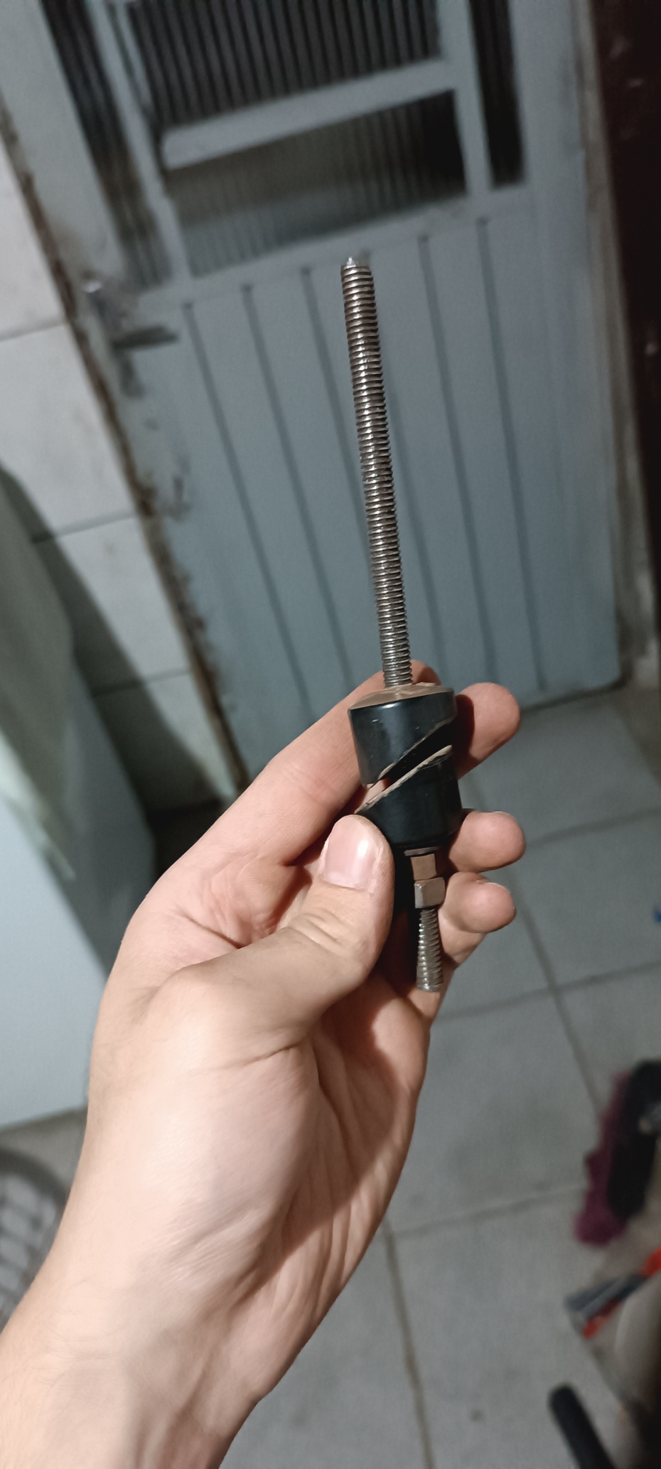 Com duas porcas e a barra roscada, prenda uma contra a outra, coloque uma arruela e os dois tampões