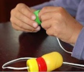 Enfie as tampinhas no barbante, uma a uma, até formar o corpo. Você pode intercalar cores ou formar padrões.