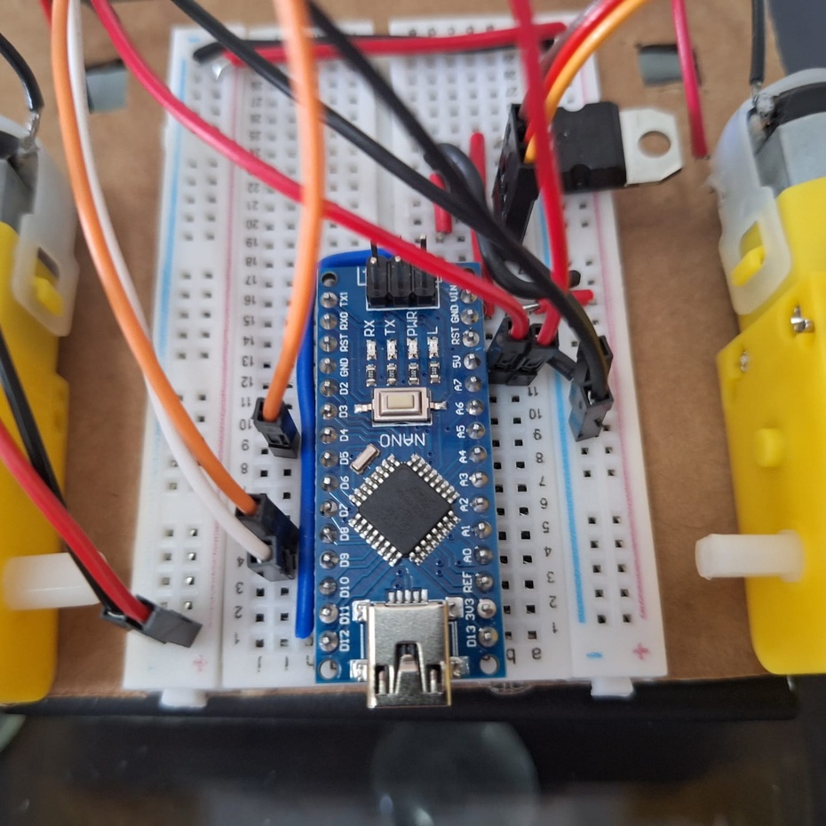 Conecte o pino de sinal do sensor infravermelho no pino D4 do Arduino. O pino 5V na trilha positiva da protoboard e o GND na trilha negativa da protoboard. PASSE OS FIOS PELO BURACO ATRÁS DO SENSOR.