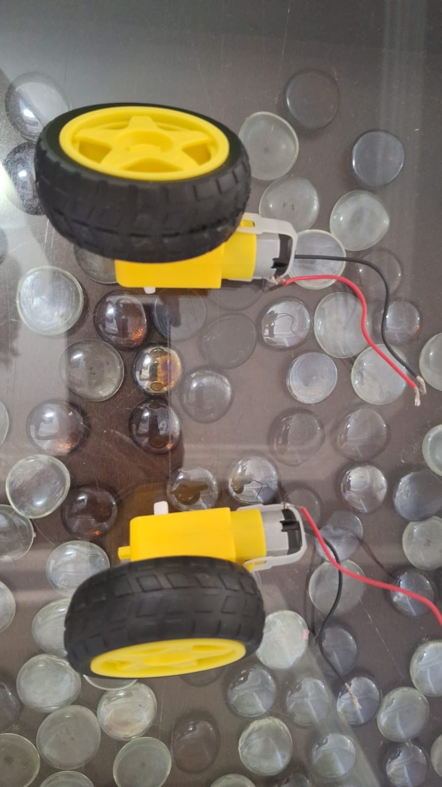 Teste a polaridade dos motores usando uma bateria para ver em qual combinação de positivo/negativo eles giram para o sentido horário/anti-horário. Sinalize esta informação nos motores usando uma caneta permanente. Depois, posicione-os de acordo com a imagem.