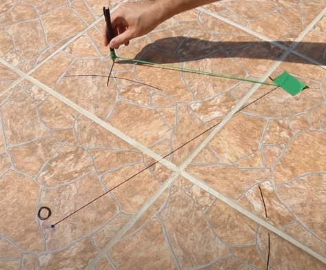 Utilize um esquadro para desenhar uma linha perpendicular à linha leste/oeste, e está será a linha norte/sul.

a. Caso não tenho um esquadro disponível ou prefira usar outros métodos, é possível encontrar esta reta utilizando o mesmo fio usado anteriormente para desenhar o semicírculo, e realize procedimento semelhante, fixando uma ponta da linha ao primeiro ponto de sombra marcado, e fazendo outro semicírculo em direção ao outro ponto, depois repita o processo com a linha fixada ao segundo ponto, e o semicírculo apontado para o primeiro ponto. 

b. Esses semicírculos então terão dois pontos de contato entre eles, trace uma reta e uma intersecção até a outra, e então esta será a linha norte/sul.