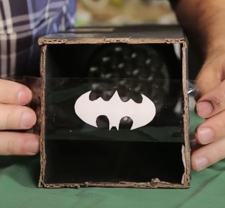 Cole a fita em um dos lados vazados do tubo 11x40cm. A imagem colada na fita precisa ficar centralizada no quadrado 11x11cm.