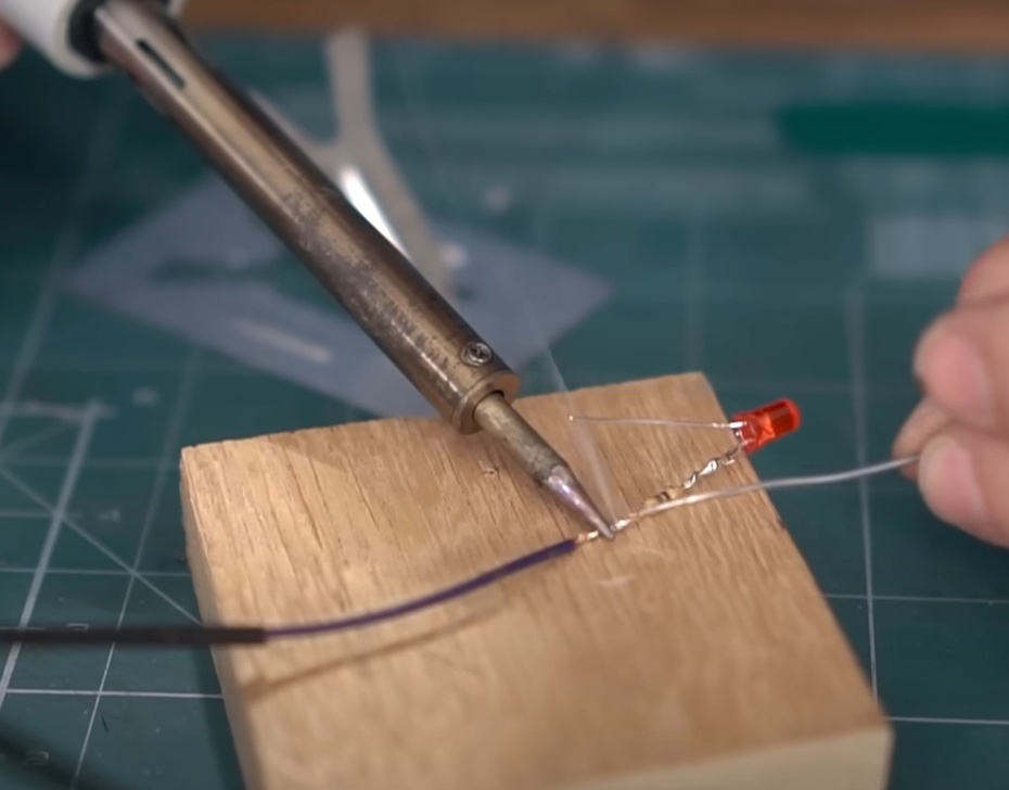 Repita para o fio preto soldado no led. A diferença é que este não tem resistor, então o tubinho pode subir um pouco mais na solda feita. 