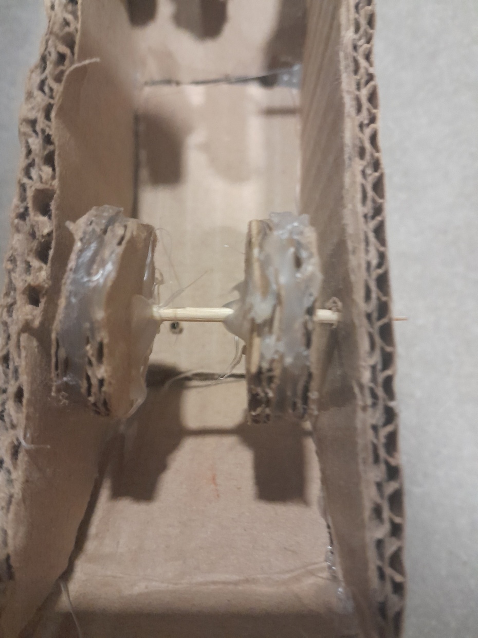 Para fazer as rodas faça 8 círculos de papelão idênticos e então cole-os com cola quente, porém após colar, passe cola pela roda para aderência, e em seguida coloque no Palito de dente e cole-as nele, do jeito mostrado a seguir