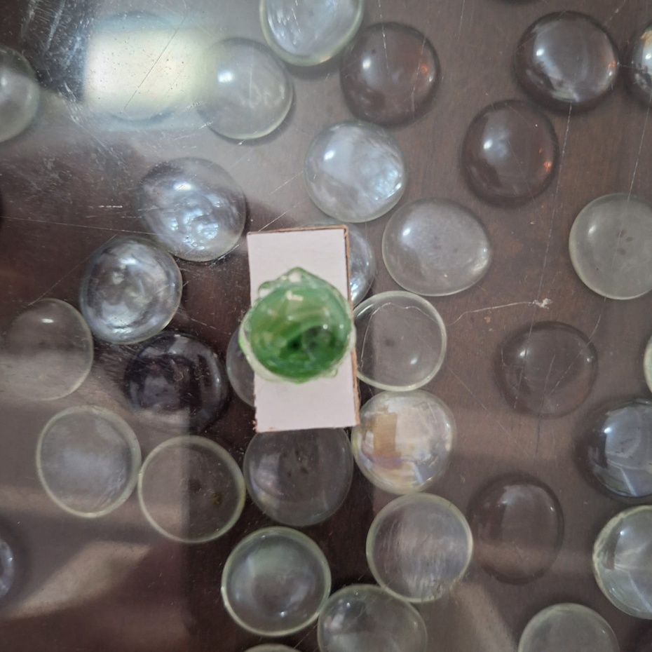 Cole, usando cola quente, a bolinha de gude sobre a peça número 5.