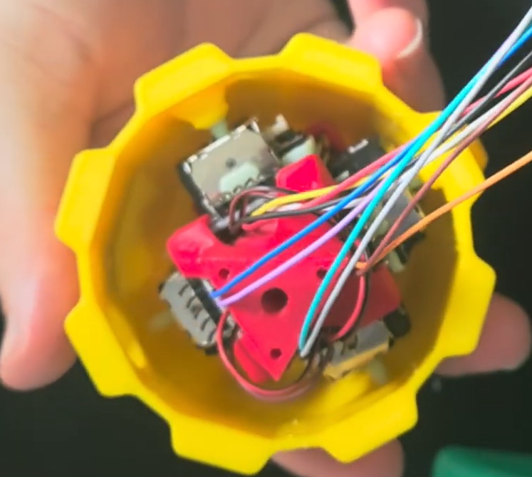 Prenda 2 das Bolas a joysticks um ao lado do outro. Coloque o Manipulador nelas e, através dos buracos, prenda as outras 2 bolas.