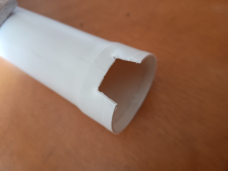 Fazer um corte em uma das extremidades do cano um pouquinho mais profundo que a largura da lupa e mais largo que o cabo da lupa.