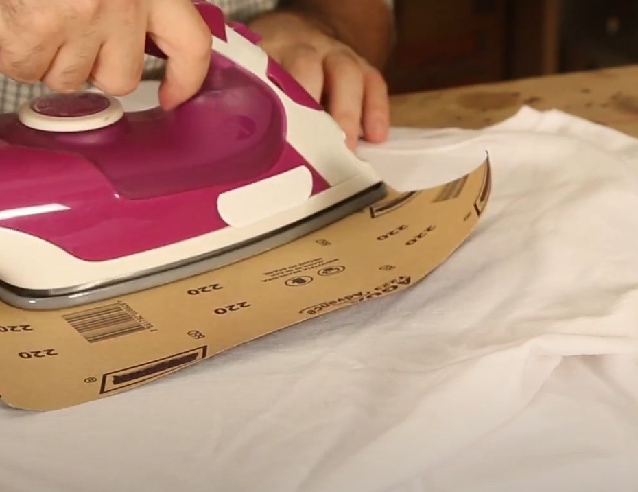 Passe devagar o ferro de passar sobre a lixa com o desenho. Dessa forma o calor do ferro de passar irá derreter o giz de cera e ele vai penetrar nas linhas da camiseta. PEÇA AJUDA PARA UM ADULTO SE NECESSÁRIO.