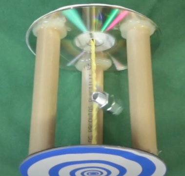 A estrutura da “lata sem paredes” está pronta, agora repita os passos com elásticos, parafusos e pregos, mas como o CD já é furado pelo meio, não será necessário reproduzir os primeiros passos da montagem da lata.