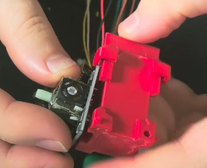 Prenda os Joysticks na peça central. Você pode usar parafusos ou a peça Prendedor para isso. Ela foi feita para ter um joystick de cada lado, com os fios indo para baixo (para a base triangular).