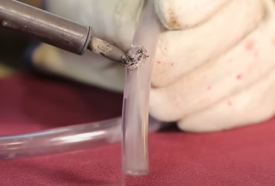 Utilizando o ferro de solda, faça um furo no meio da maneira de 10cm. O furo não deve atravessar os dois lados da mangueira e deve ter tamanho suficiente para encaixar a outra mangueira (aproximadamente 1,27cm). MUITO CUIDADO NESTE PROCESSO! USE EQUIPAMENTO DE PROTEÇÃO! CRIANÇAS PEÇAM AJUDA PARA UM ADULTO.