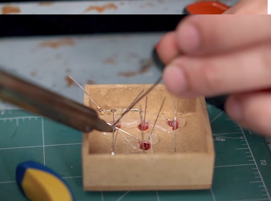 Após soldar todos os terminais negativos juntos, solde uma ponta do resistor de 470R junto a eles.