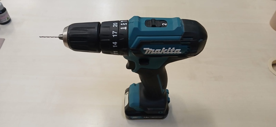 Para a fixação, inicialmente utilizou-se cola de madeira, porém não se obteve uma boa aderência. Diante disso, a melhor solução encontrada foi realizar a fixação com pregos. Para evitar que o MDF rachasse e garantir que o prego entrasse com facilidade, foram feitos pré-furos com uma broca de 1 mm. Já na base, utilizou-se adesivo instantâneo do tipo cianoacrilato para prender as peças de suporte.