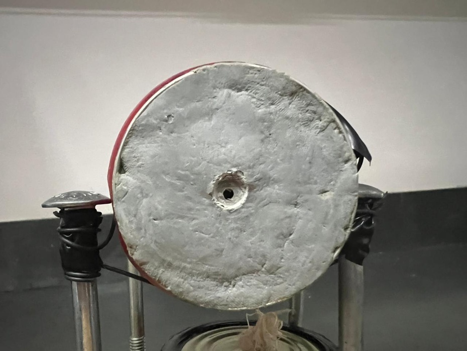 Esvazie o conteúdo da latinha, lave-a. Depois de seca ponha o Durepoxi  na tampa da lata tampando o buraco, espere secar por aproximadamente 12 horas, se for preciso faça mais uma camada.  Após o Durepoxi secar faça um pequeno furo na tampa da lata. Fixe a lata sobre os parafusos com arame e fita isolante.